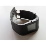 A FitBit on black rubberised strap.