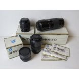 Four Minolta camera lenses, three having