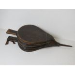 A large pair of wooden and leather fire bellows.