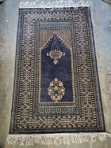 A woollen rug in blue ground with floral pattern approx. 150 x 95cm.