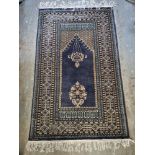 A woollen rug in blue ground with floral pattern approx. 150 x 95cm.