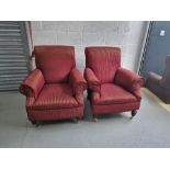 A pair of armchairs in burgundy and gold fabric having turned legs with castors to front,