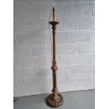 A carved wooden standard lamp base having reeded and twisted design.