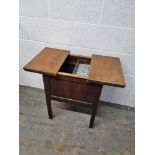 An Oak workbox raised over square shaped legs,