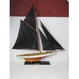 A model pond yatch 'Columbia' having black sails, approx 82cm in length.