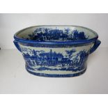 A large blue and white planter, blue glaze, Italian style city scenes upon.