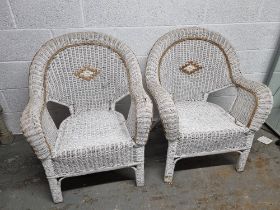 A pair of wicker conservatory chairs.