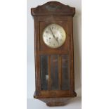 An oak cased hanging wall clock having silvered dial and black Arabic numerals,