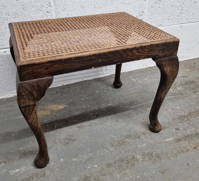 A cane topped footstool.