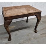 A cane topped footstool.