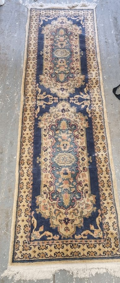 A woollen runner in cream and blue ground in need of cleaning, measuring approx. 240 x 68cm.