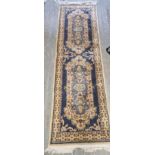 A woollen runner in cream and blue ground in need of cleaning, measuring approx. 240 x 68cm.