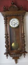 A mahogany wall clock having brass and white enamelled dial,