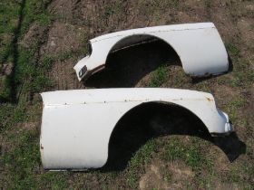 A pair of vintage car wings with headlight mounts and indicators, believed to be for an MG.