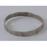 A HM silver bangle having overlapping oval pattern upon, London Jubilee hallmark upon, 5.2cm dia.