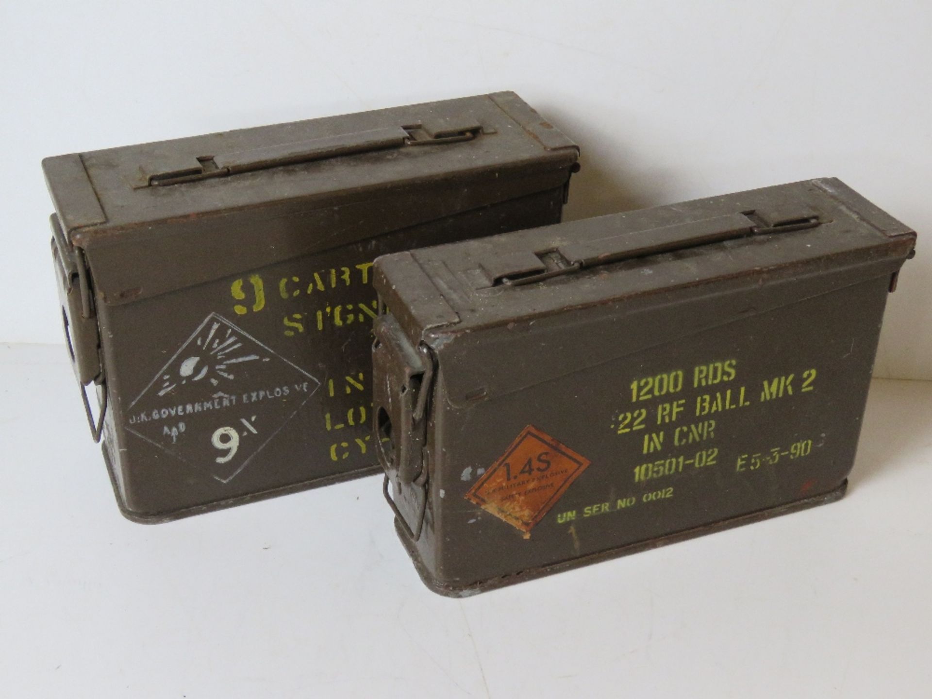 Two cartridge canisters, one marked UK Military Explosives, the other marked Signal Red.