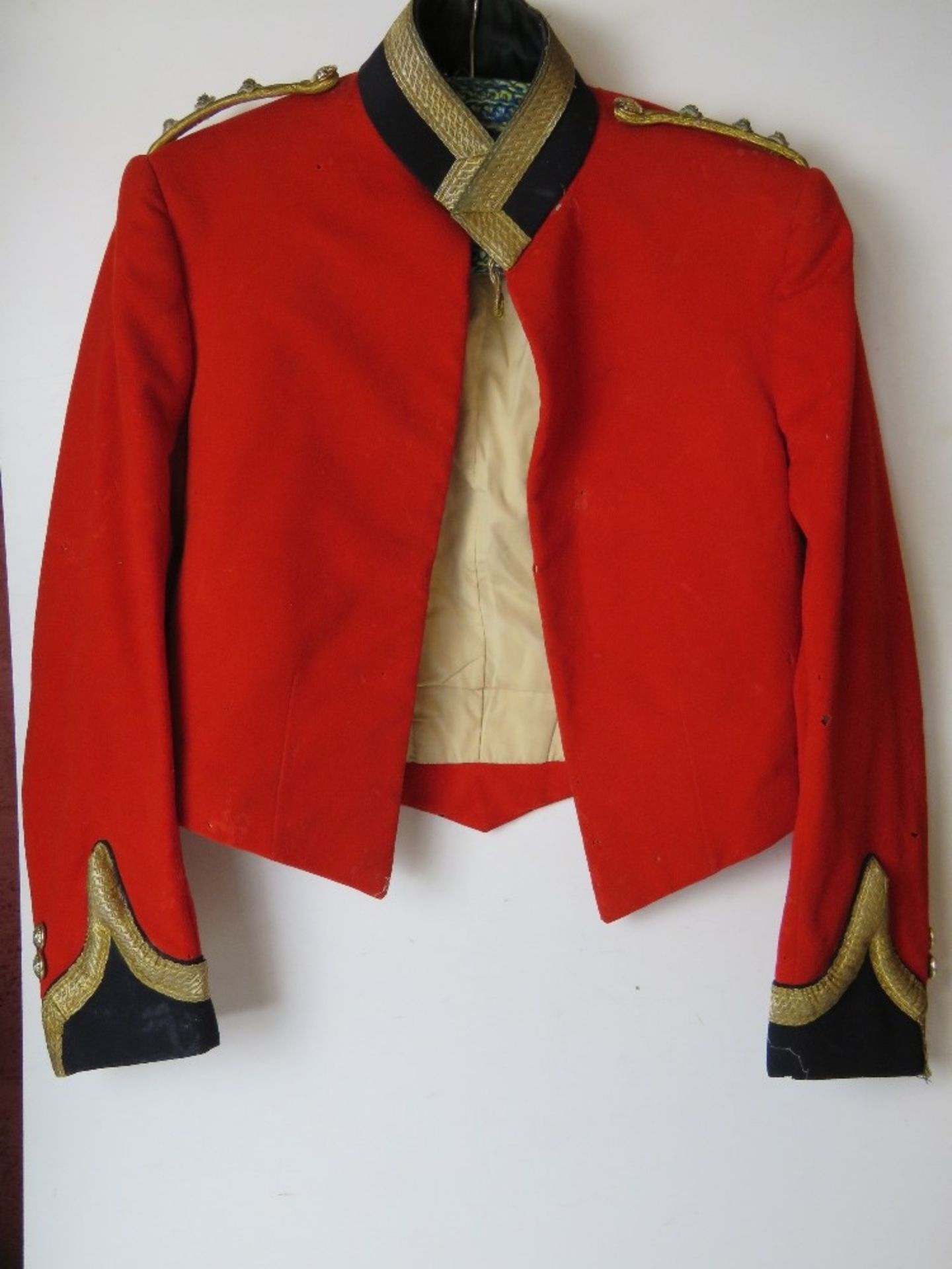 A red military jacket having buttoned and shoulder cords upon, a/f, heavy mothing.