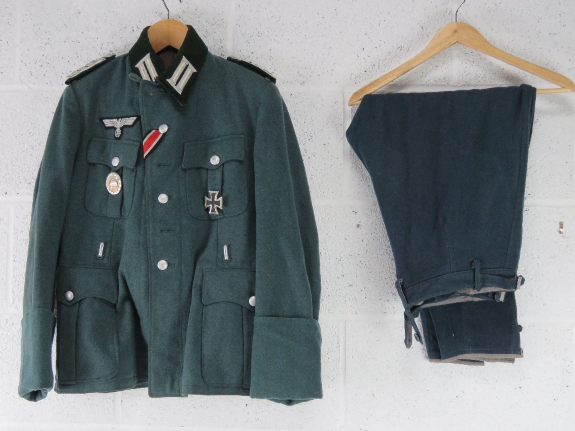 A reproduction German Combat Jacket with Insignia, and breeches.
