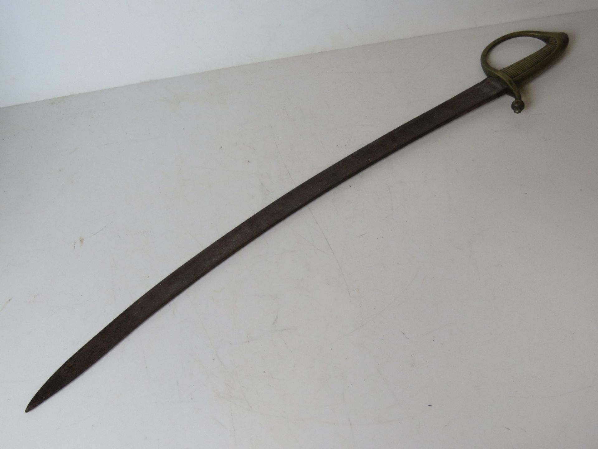 A continental late 18thC/early 19thC brass handle hanger sword with curved single edge blade,