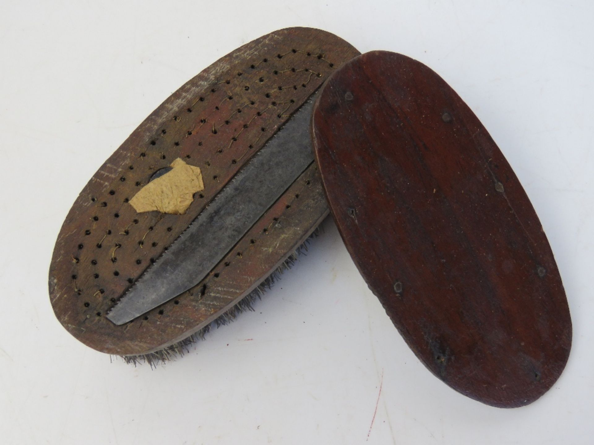 A WWII E&E (Escape & Evasion) boot brush with saw. Compass within.