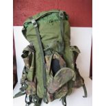 A Berghaus camouflage military rucksack containing a large quantity of kit inc black leather boots,