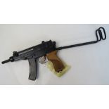 A deactivated Czech Skorpion Wz61 7.65mm sub machine gun with chequered wooden grip.