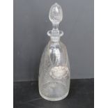 A cut glass decanter having etched floral design upon with silver plated whisky label,