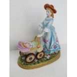 A Dresden Porcelain figurine of a lady pushing a pram, arm a/f, hand painted and gilded throughout,