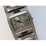 A ladies white stone encrusted wrist watch by Guess, case back deficient.