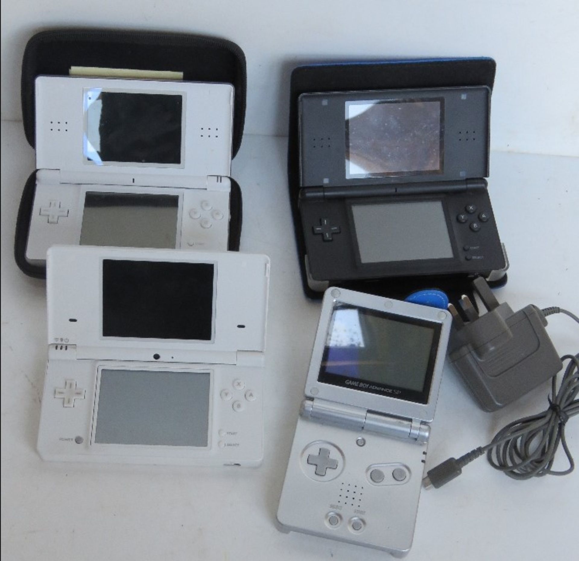 A Nintendo Gameboy Advance together with three other Nintendos.