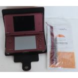 A Nintendo DS XL in burgundy with case, instructions and stylus.