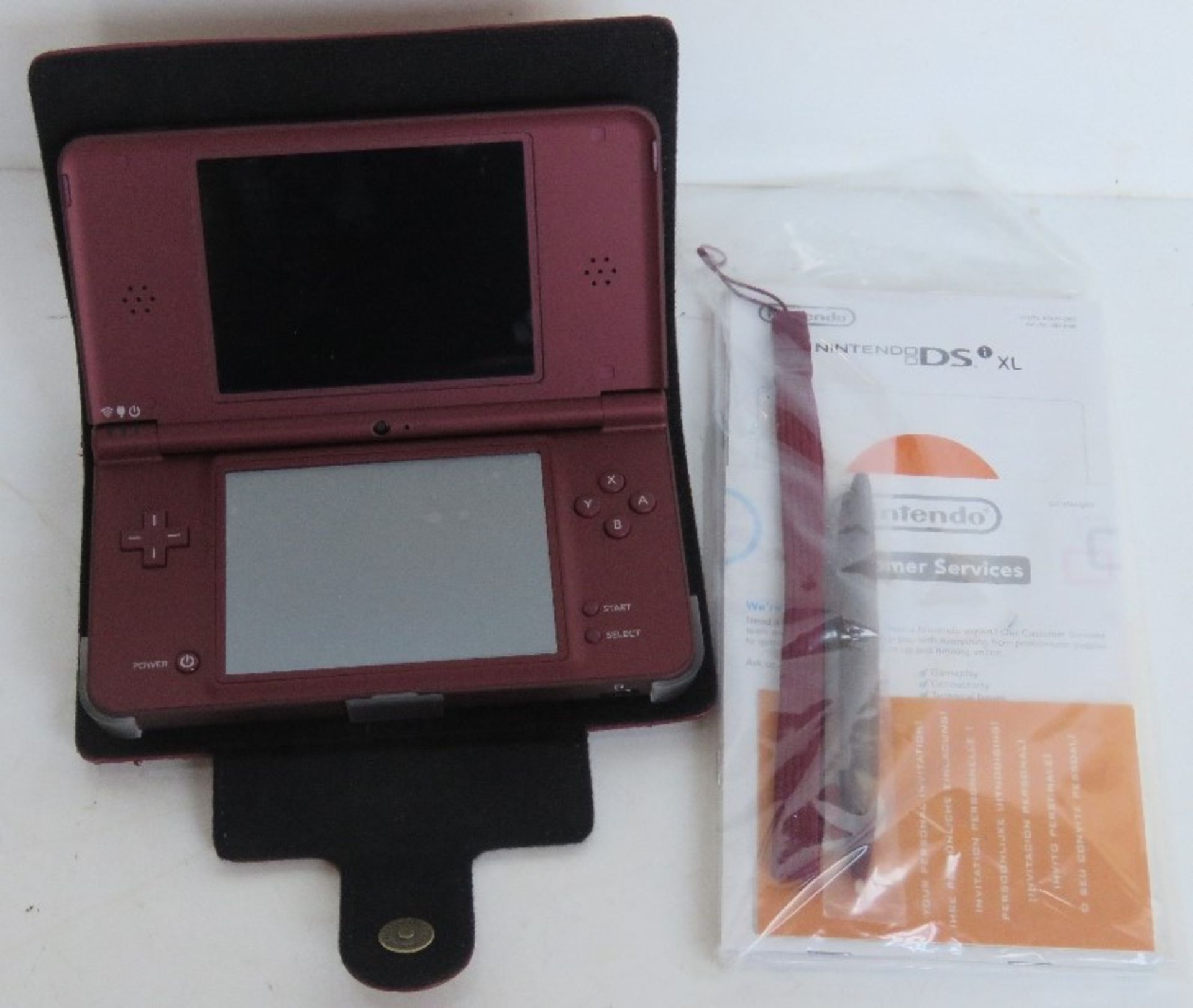 A Nintendo DS XL in burgundy with case, instructions and stylus.