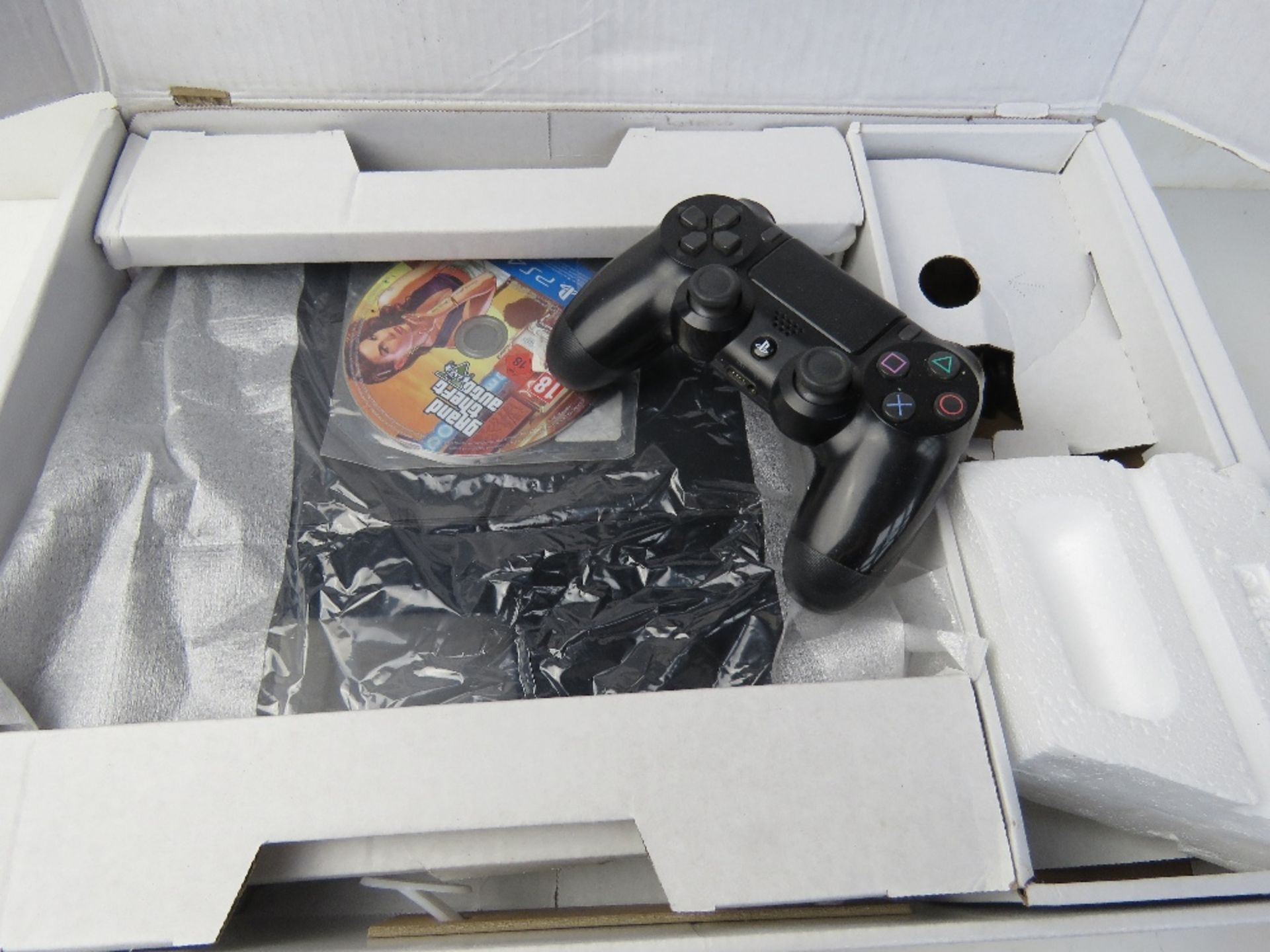A PS4 Slim console in box with controller and game.
