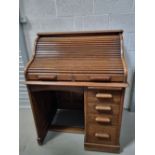 An early 20th century oak roll top desk ' The Lebus Desk' having four graduated drawers with slide