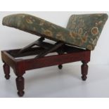 An antique gout stool having green floral velvet upholstery.