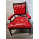 A Victorian Gothic Revival library chair upholstered in red leather and having floral carving to