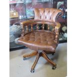 A brown Chesterfield type captain's chair in need of light refurbishment. (castor deficient).