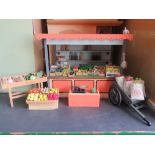 A dolls house greengrocer's market stall with wares, barrow of sacks, etc.