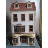 A dolls house having well stocked butchers shop to the ground floor with home over three upper