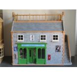 A dolls house having been designed as a greengrocer's with generous array of products on display,