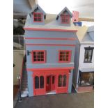 A dolls house furnished as a public house with home over, outside sign and lamp, barrel cart,