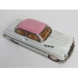 A 1/18 scale model car in pink and white, metal construction.