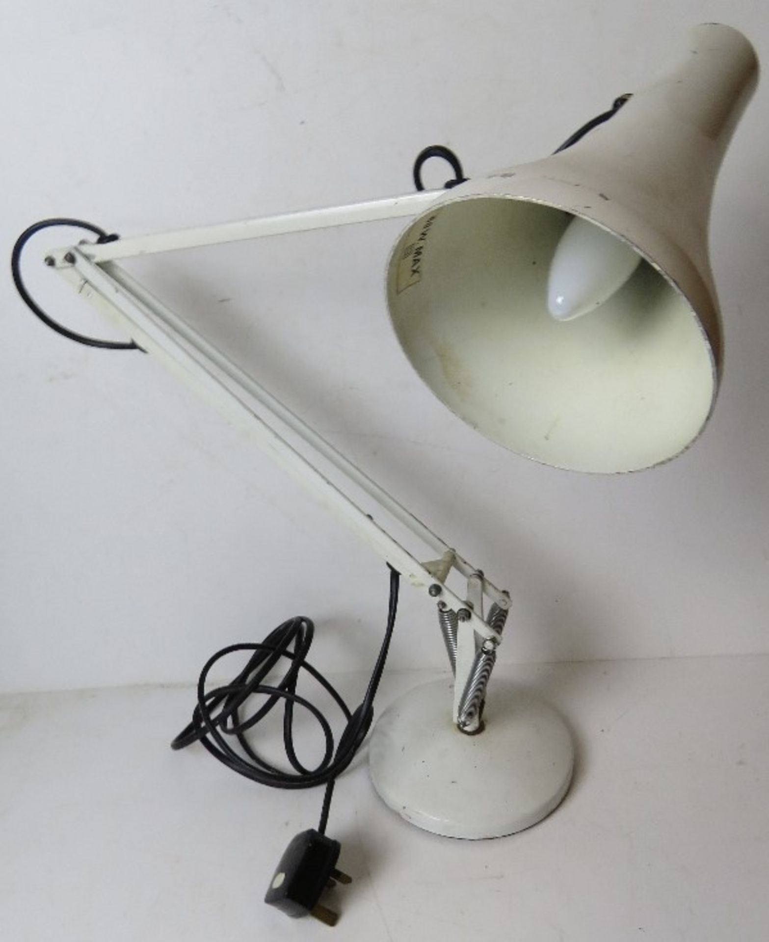 A white metal angle poise type desk lamp.