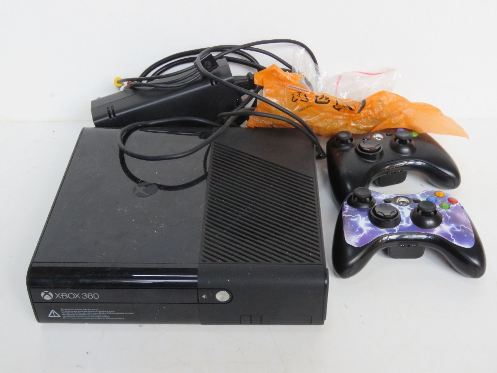 An Xbox 360 with cables and controllers.