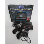 A Sega Mega Drive II console with controllers and cable in original box.