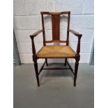 A single cane seated carver chair.