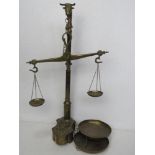 A brass set of balance scales with weights having bulls head finial and standing 59cm high.