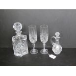 A pair of Edinburgh crystal champagne flutes together with a cut glass decanter and a cut glass