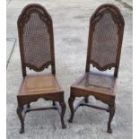 A pair of finely carved oak chairs with cane work seats (one restored, one a/f).
