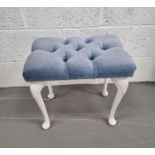 A dressing table stool upholstered in blue velour fabric.